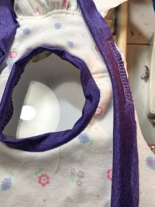 Neckband sewn in the round, shoulder band partially attached.